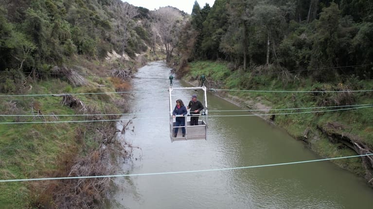 The Burgess family uses a flying fox to get across the Hangaroa River in Gisborne after an access bridge was destroyed during Cyclone Gabrielle.