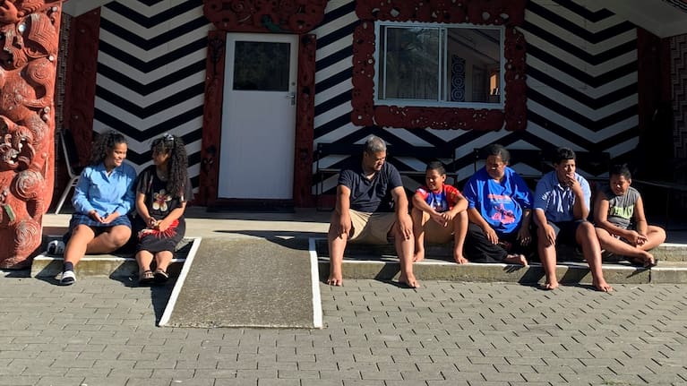 The Perese family sit outside the Waipatu Marae.