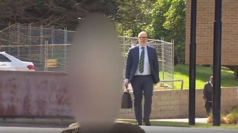 The sportsman (blurred) outside court alongside lawyer Ron Mansfield on December 4, 2019.