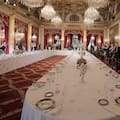 Visitors view a table dressed with plates and glasses for official dinners at the Elysee Palace in Paris, Saturday