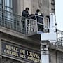 Workers install metal security bars over the window where thieves broke into the Louvre museum